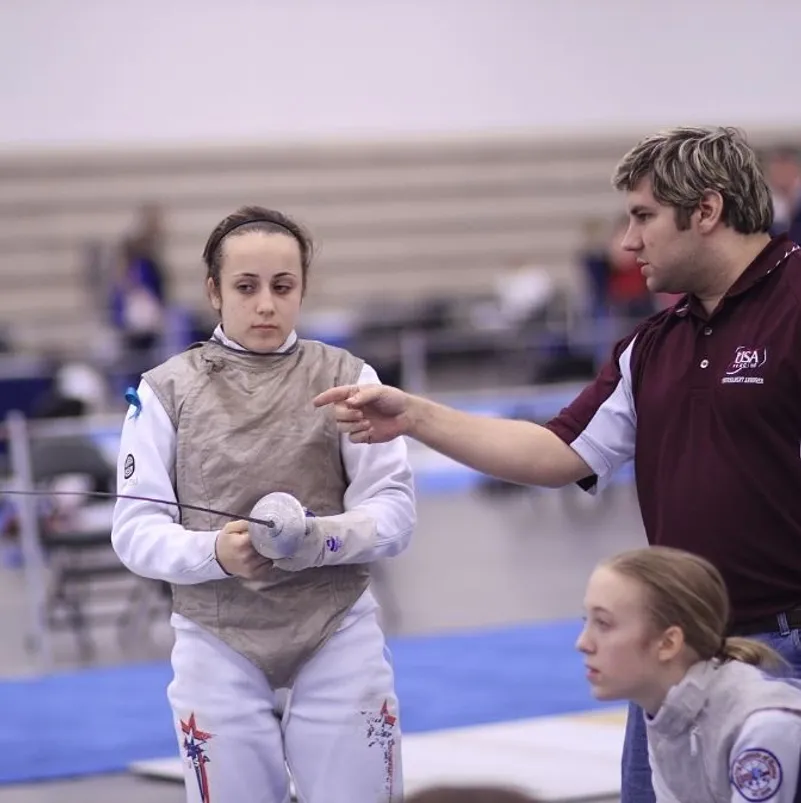 A coach giving technical direction during a fencing competition